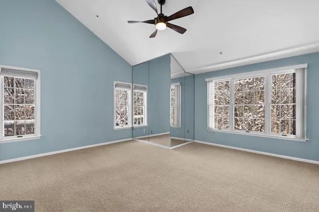 a view of an empty room with a window and a ceiling fan