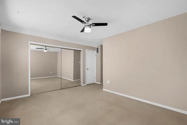 an empty room with a ceiling fan and shower