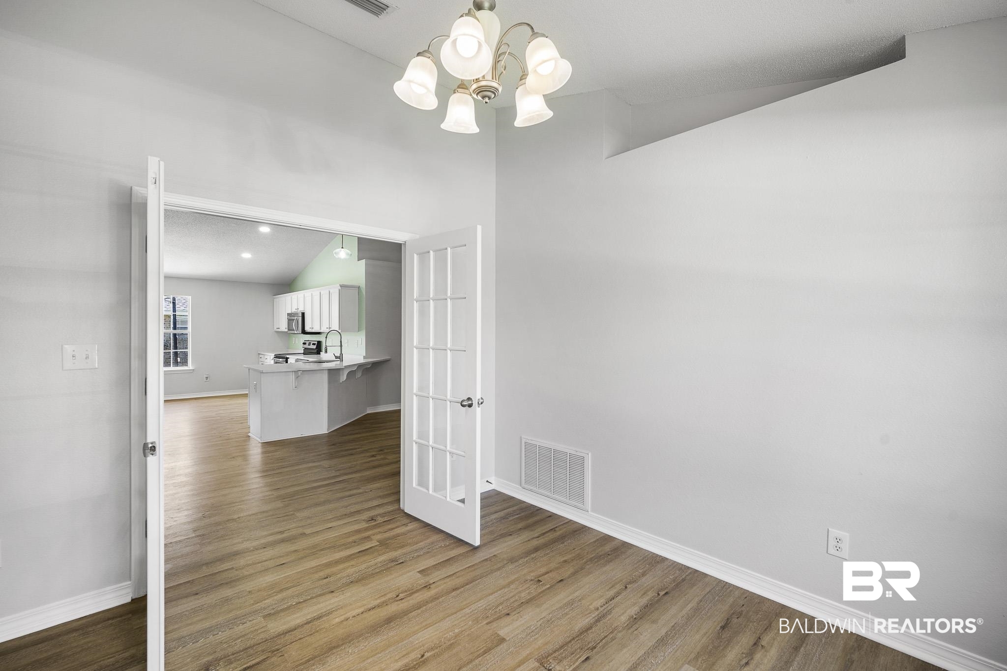 9814 Woolrich Avenue Fairhope, AL 36532 - Photo 13 of 29 Interior space featuring sink, light hardwood / wood-style flooring, vaulted ceiling, and a chandelier