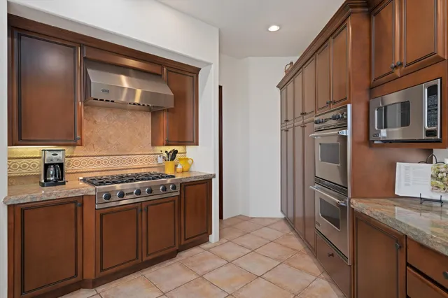 a kitchen with a sink a stove and cabinets