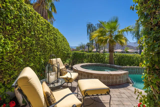 a view of swimming pool with a garden and plants
