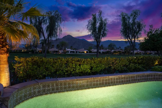 a living room with furniture a fireplace and a floor to ceiling window