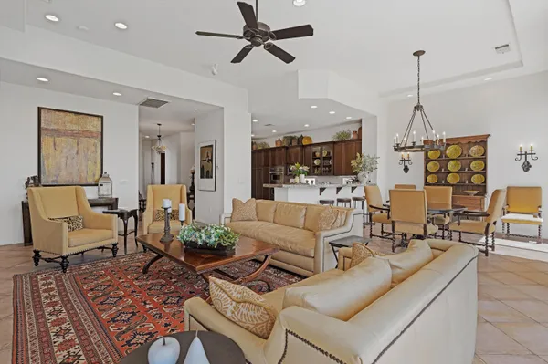 a living room with furniture ceiling fan and a large window