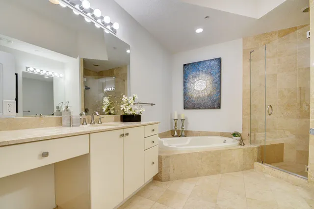 a bathroom with a tub a sink and mirror
