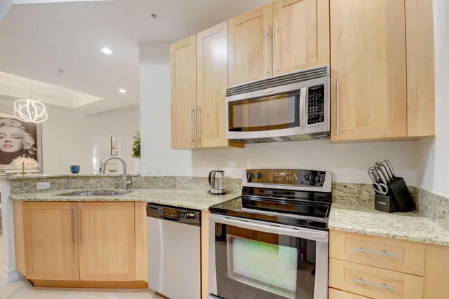 a kitchen with granite countertop cabinets stainless steel appliances and a counter space