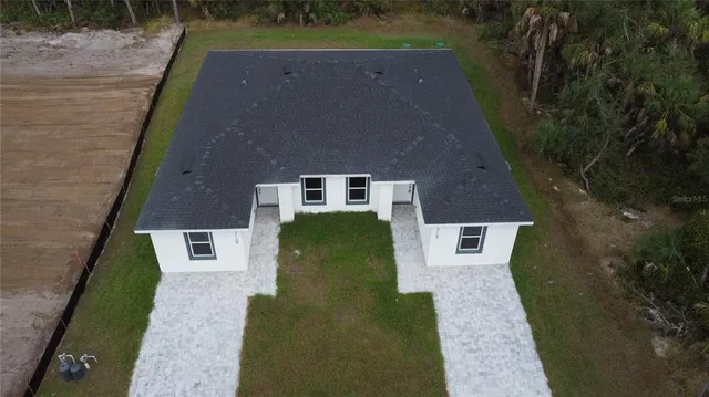an aerial view of a house with a yard