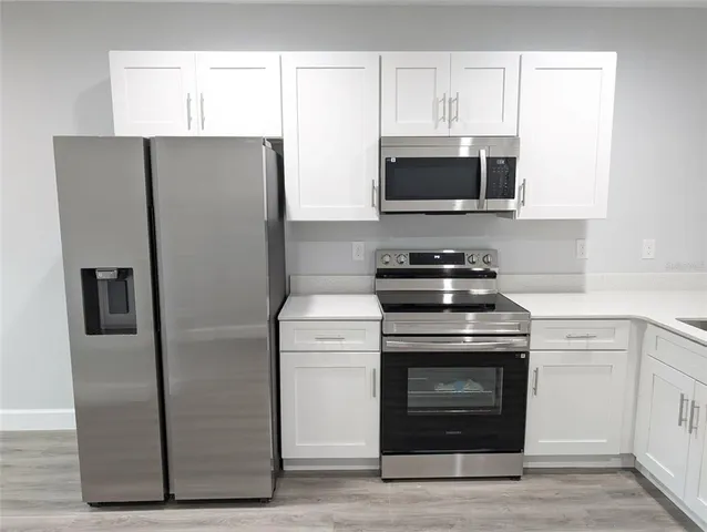 a kitchen with stainless steel appliances a refrigerator stove and microwave