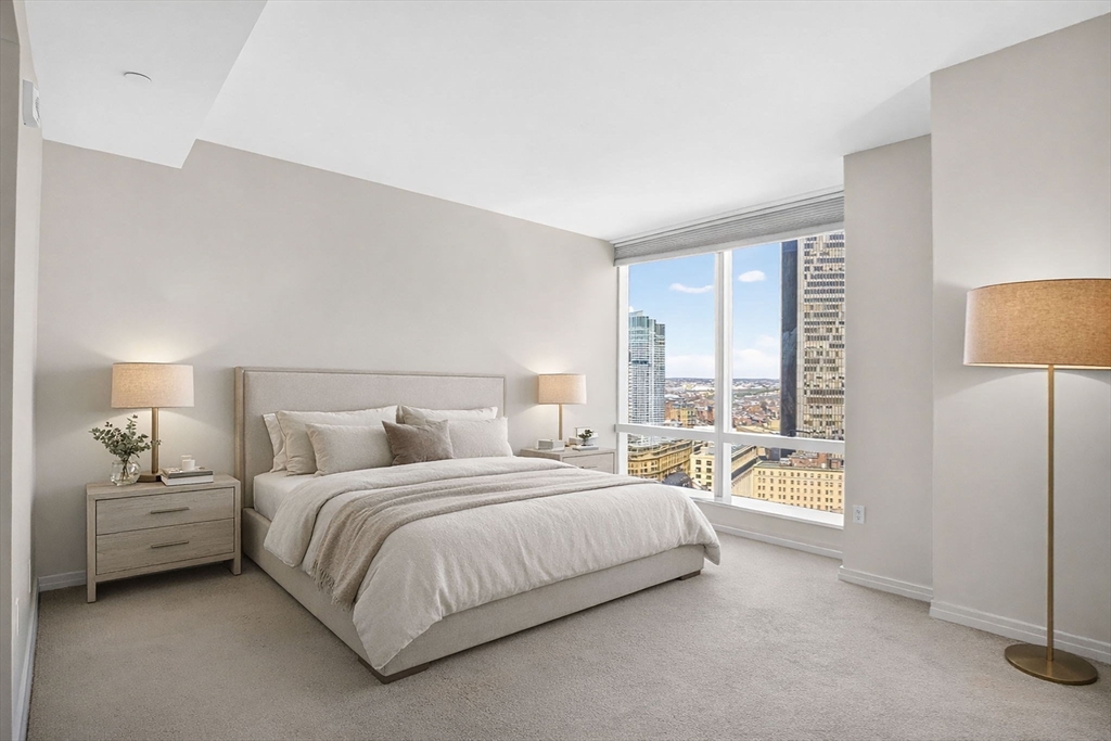 1 Franklin Street, Unit 2805 Boston, MA 02110 - Photo 7 of 22 a bedroom with a bed a lamp and a large window with balcony view