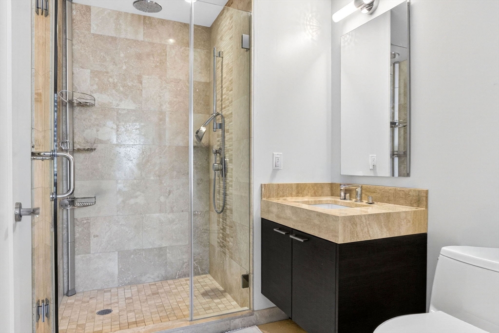 1 Franklin Street, Unit 2805 Boston, MA 02110 - Photo 8 of 22 a bathroom with a sink toilet shower and a mirror