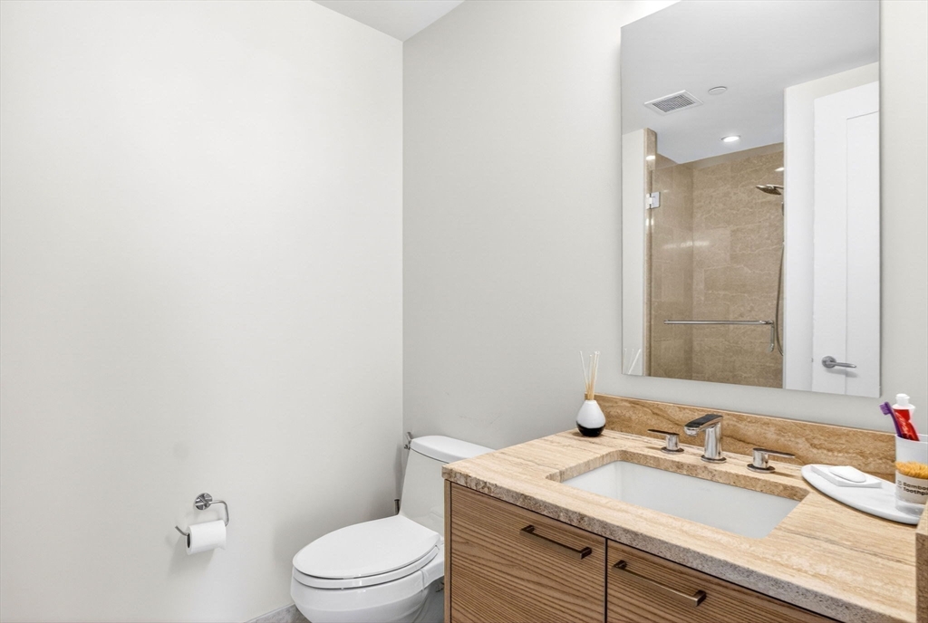 1 Franklin Street, Unit 2805 Boston, MA 02110 - Photo 10 of 22 a bathroom with a granite countertop sink mirror vanity and toilet