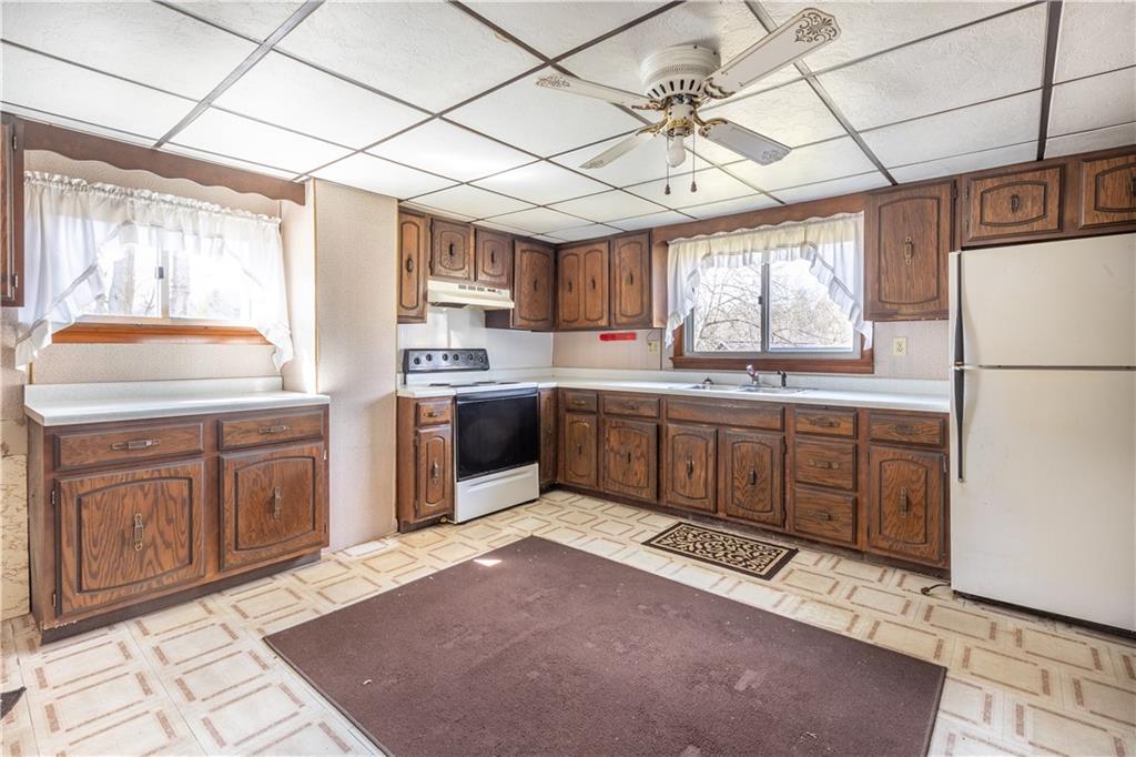 3348-3350 Springfield Pike Normalville, PA 15469 - Photo 20 of 25 a kitchen with stainless steel appliances granite countertop a sink a stove a refrigerator cabinets and a window