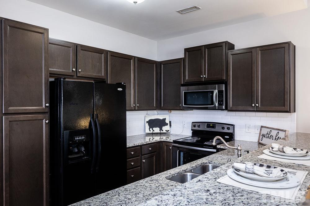 844 Horton Road, Unit 87 Durham, NC 27704 - Photo 6 of 21 a kitchen with stainless steel appliances granite countertop a refrigerator stove and microwave