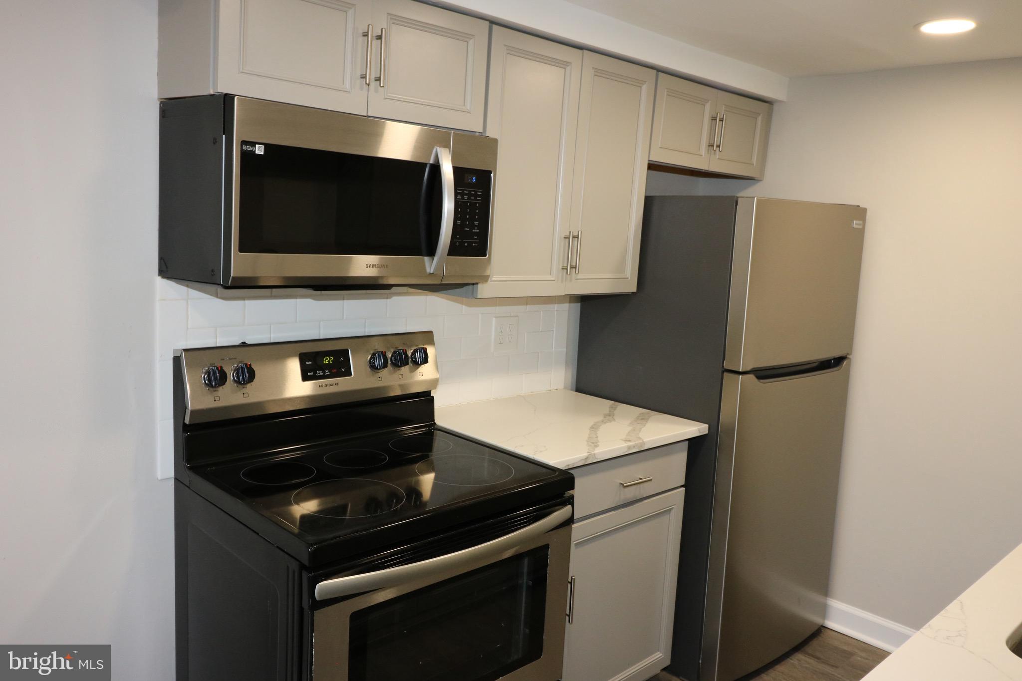 1717 Fort Henry Court Dumfries, VA 22026 - Photo 7 of 27 a kitchen with stainless steel appliances a stove microwave and refrigerator