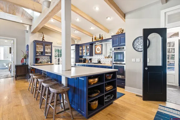 a kitchen with stainless steel appliances granite countertop a table chairs and a dining table view