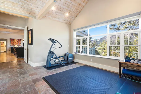 a room with gym equipment and large windows
