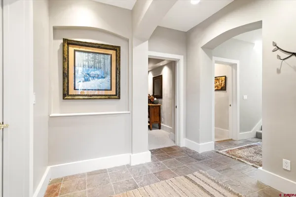 a view of a hallway with wooden floor and a living room