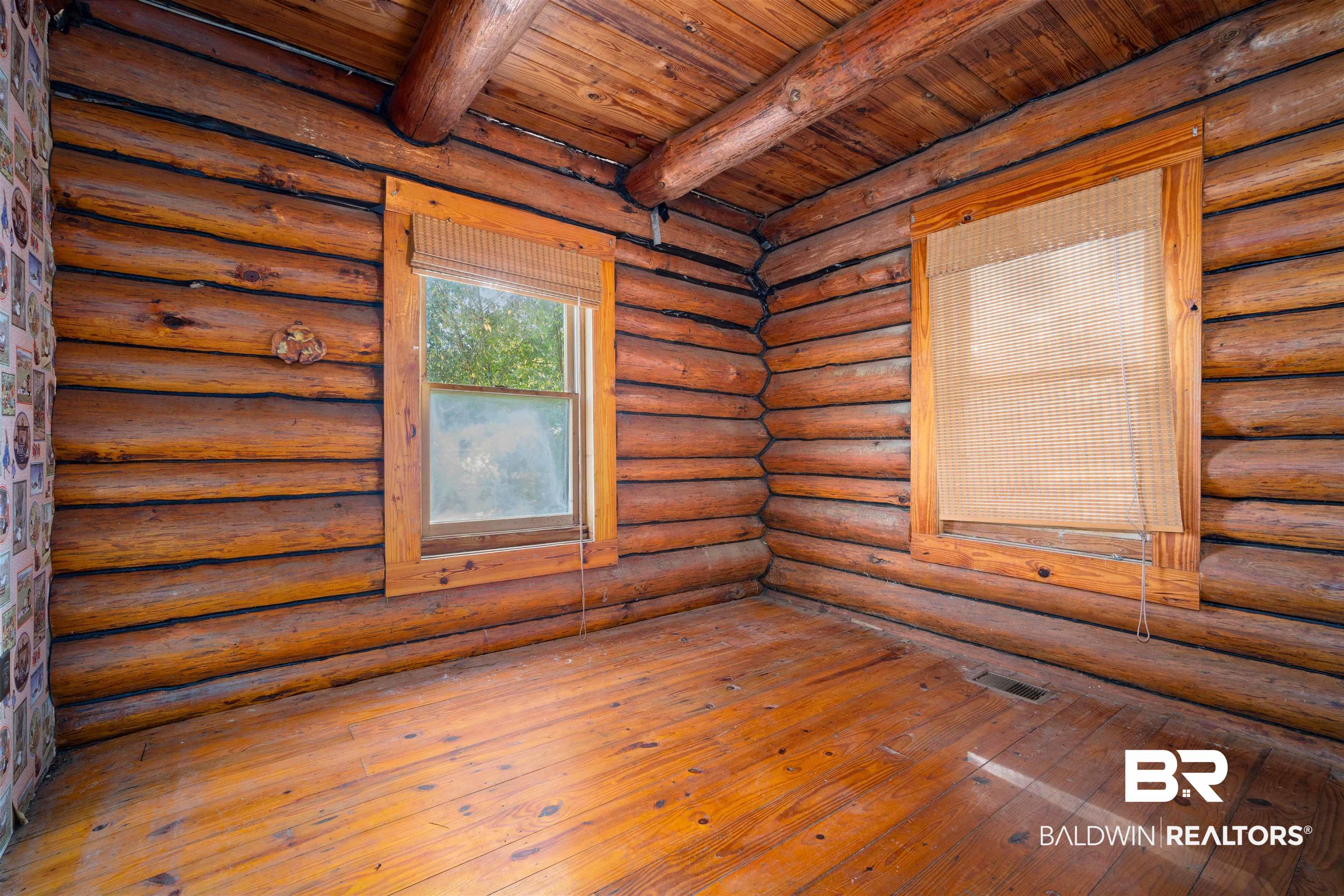 11236 Wren Avenue Fairhope, AL 36532 - Photo 19 of 35 Empty room with a wood ceiling with exposed beams, rustic walls, and wood-type flooring