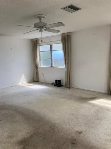 a view of a livingroom with a ceiling fan and window
