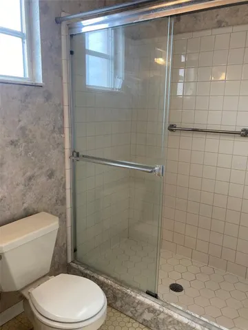 a white toilet next to a bathroom