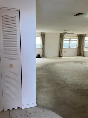 a view of an empty room with window and bathroom
