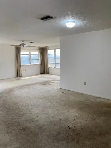 a view of an empty room with window and fireplace