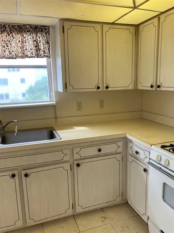 a view of a kitchen with white cabinets and a stove top oven