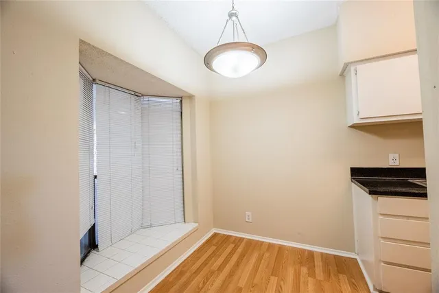 a view of a room with wooden floor and white walls