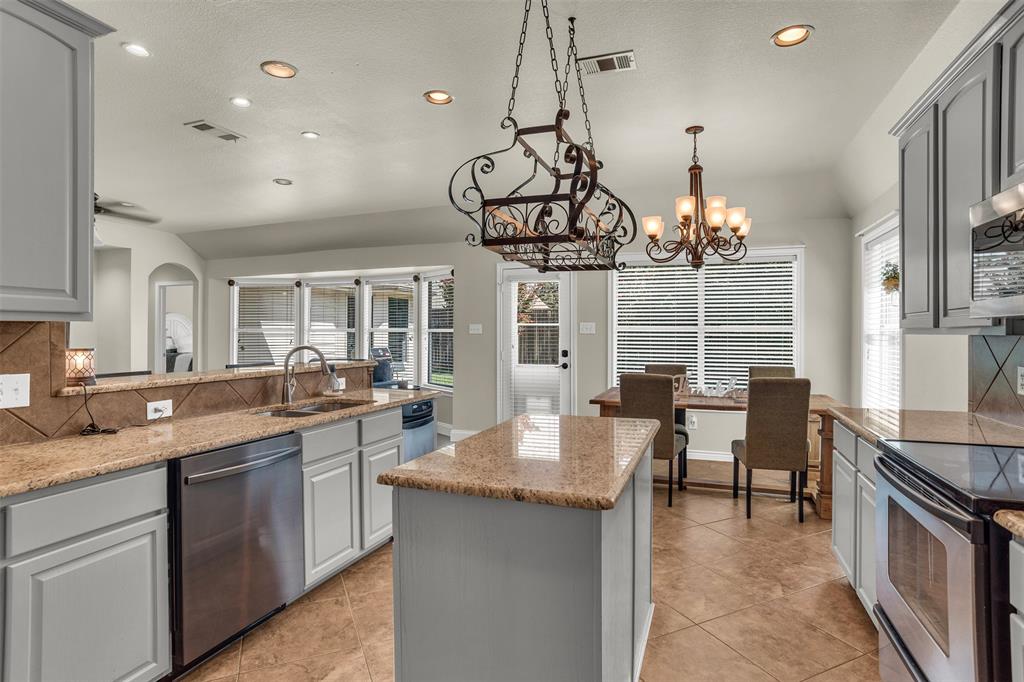 2309 Ranch House Drive Denton, TX 76210 - Photo 8 of 28 a kitchen with granite countertop a sink stove and cabinets