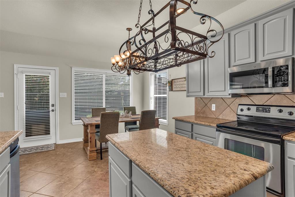 2309 Ranch House Drive Denton, TX 76210 - Photo 9 of 28 a kitchen with stainless steel appliances granite countertop a stove top oven a sink a dining table and chairs
