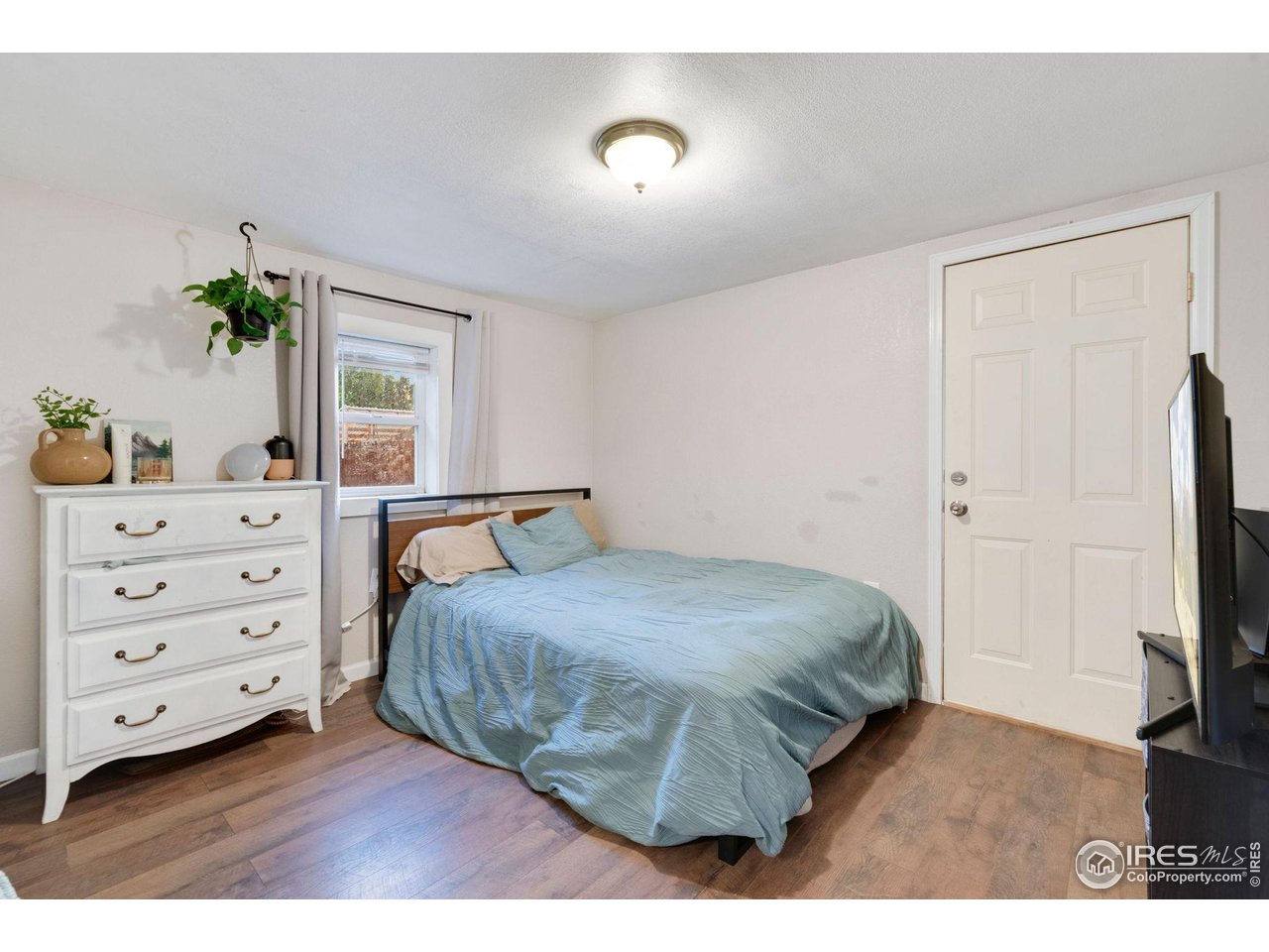 109 3rd Street Pierce, CO 80650 - Photo 13 of 21 a bedroom with a bed and a flat tv screen on dresser
