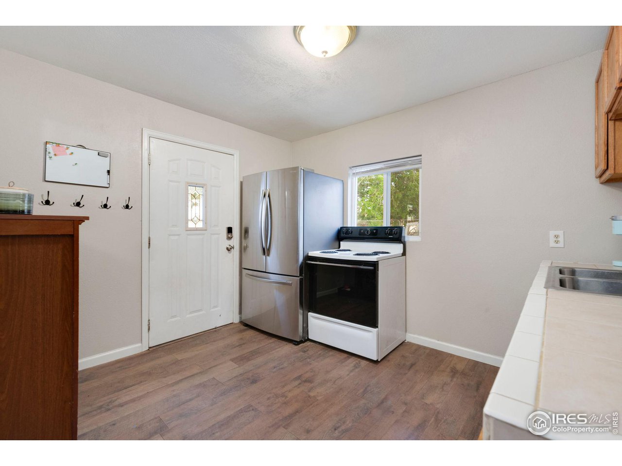 109 3rd Street Pierce, CO 80650 - Photo 7 of 21 a kitchen with stainless steel appliances kitchen island wooden floors and white walls