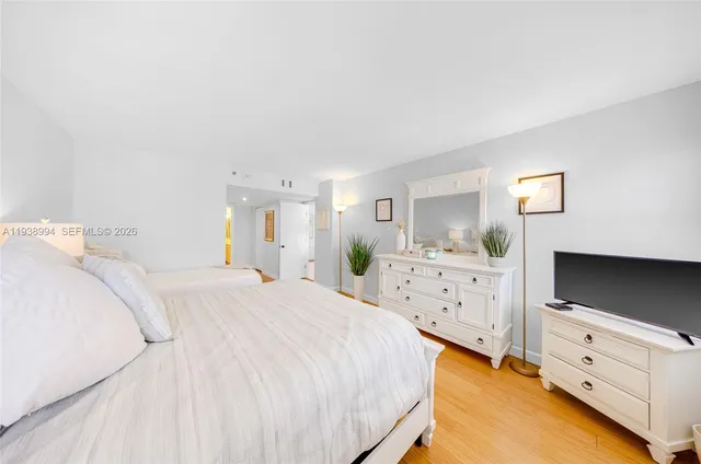 a spacious bedroom with a bed and a flat screen tv