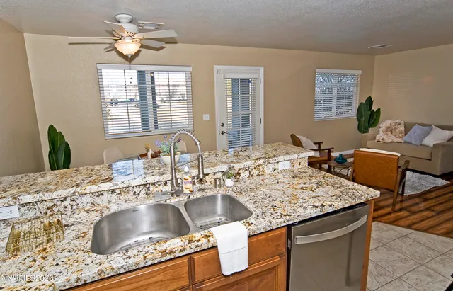 a kitchen with granite countertop a sink a counter top space and living room