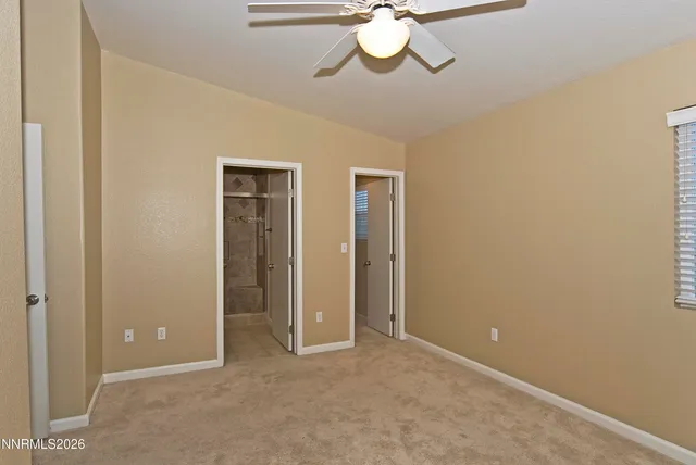 a view of an empty room with a chandelier fan