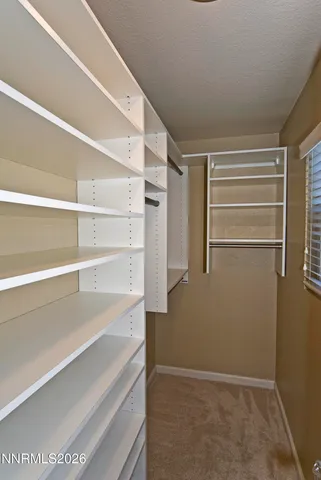 a view of walk in closet with empty racks