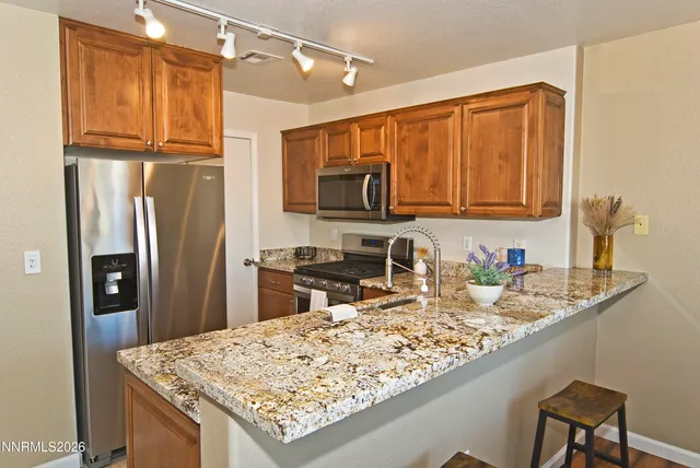 a kitchen with granite countertop a refrigerator a stove and a sink