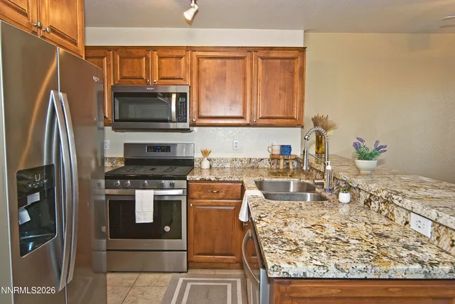 a kitchen with stainless steel appliances granite countertop a stove top oven a sink and a microwave