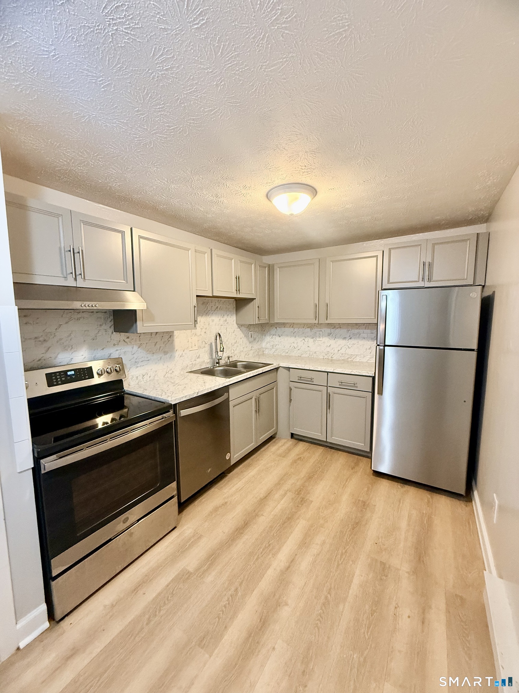 801 Pleasant Valley Road, Unit 801 South Windsor, CT 06074 - Photo 4 of 12 a kitchen with a refrigerator a stove top oven a sink and cabinets
