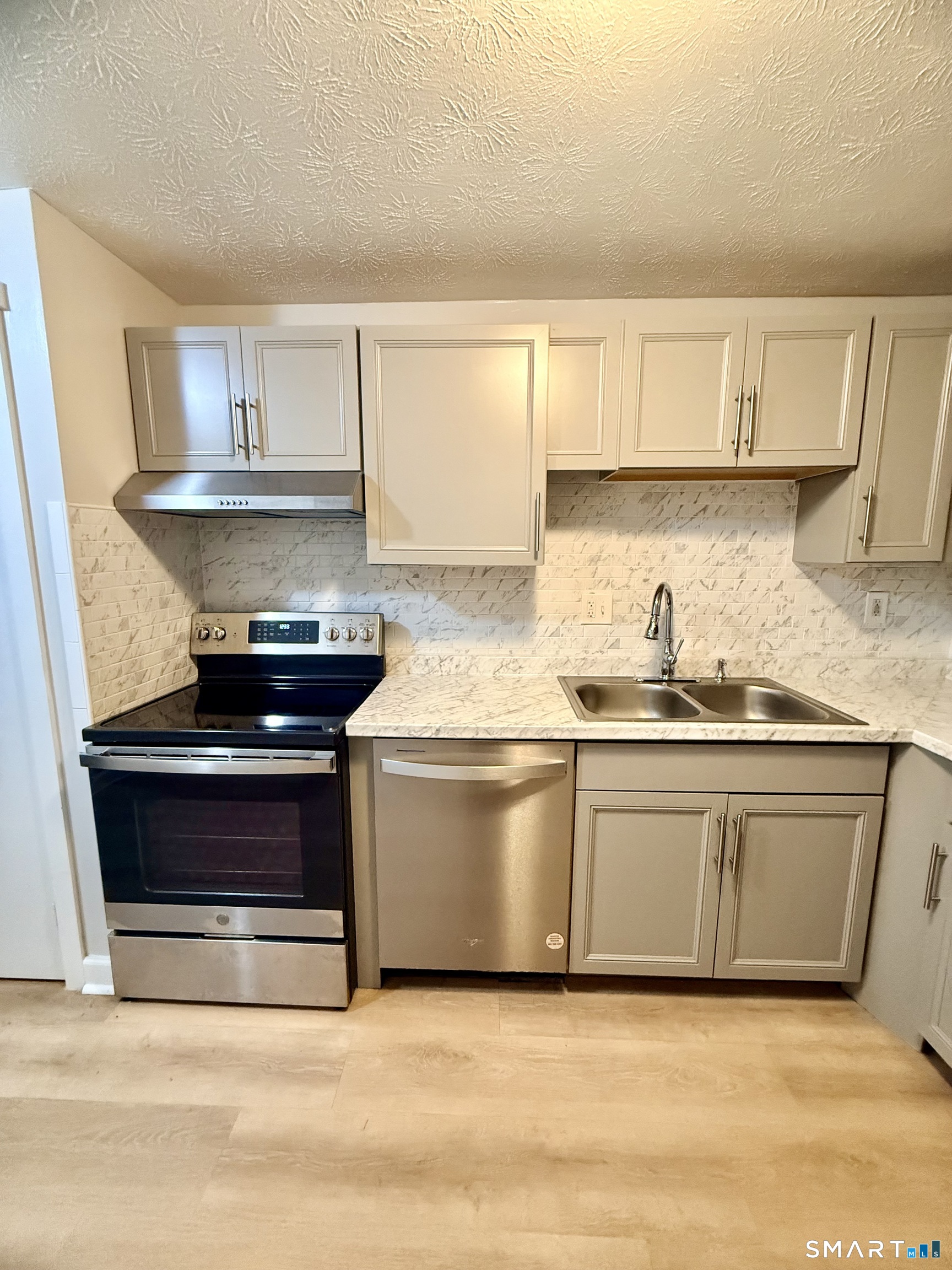 801 Pleasant Valley Road, Unit 801 South Windsor, CT 06074 - Photo 6 of 12 a kitchen with stainless steel appliances granite countertop a stove a sink and a microwave