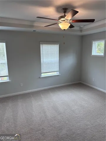 a view of an empty room with a chandelier fan