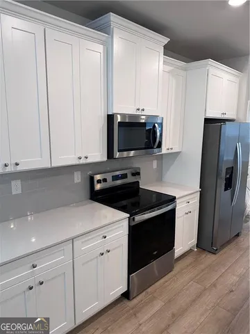 a view of a kitchen with a sink and refrigerator