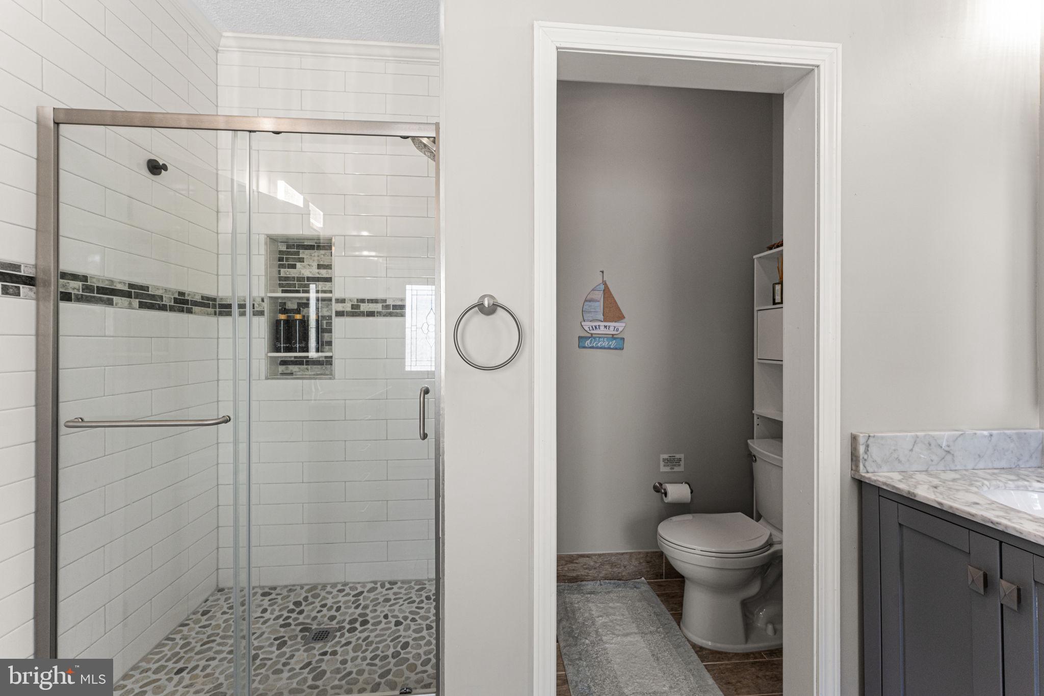249 Spring Hill Road Lancaster, VA 22503 - Photo 23 of 65 a bathroom with a granite countertop shower toilet and sink