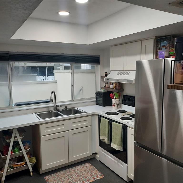 6257 Dewdrop Way, Unit 6257 Temple Terrace, FL 33617 - Photo 7 of 13 a kitchen with stainless steel appliances granite countertop a sink stove and refrigerator