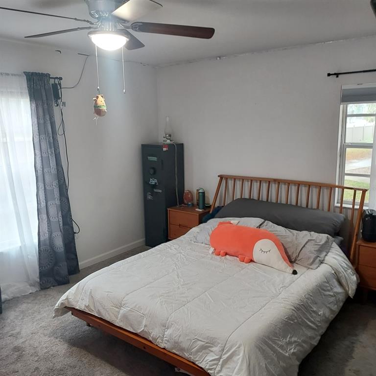 6257 Dewdrop Way, Unit 6257 Temple Terrace, FL 33617 - Photo 9 of 13 a bedroom with a bed and a chandelier