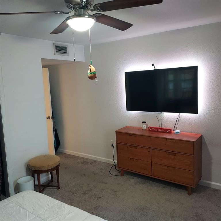 6257 Dewdrop Way, Unit 6257 Temple Terrace, FL 33617 - Photo 10 of 13 a living room with furniture and a flat screen tv