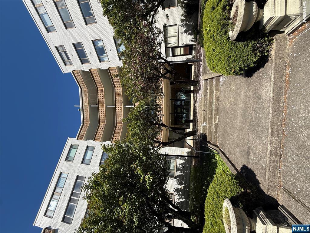 1375 River Road, Unit 1K Edgewater, NJ 07020 - Photo 2 of 15 a building outdoor space with patio furniture and garden