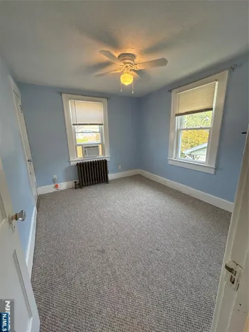an empty room with windows and fan