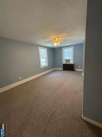 a view of an empty room with a window and a fireplace