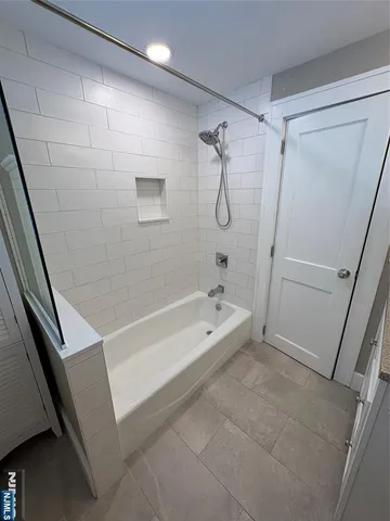 a bathroom with a bathtub a toilet and a shower