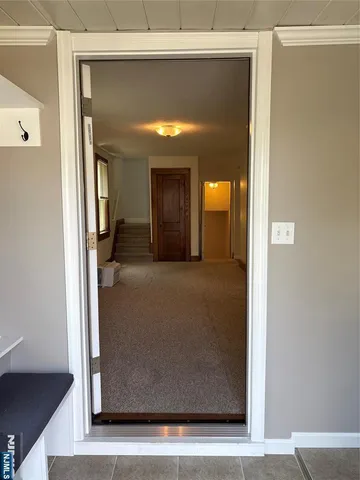 a view of a hallway with wooden floor and a living room
